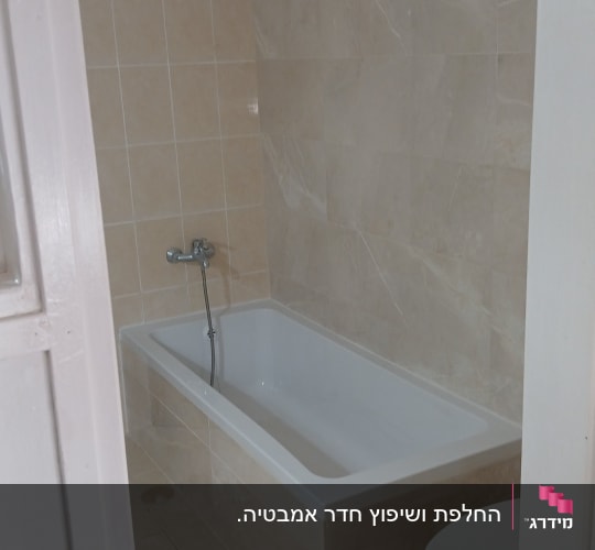 חדר אמבטיה עם אמבטיה חדשה וקירות מרוצפים